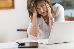 Woman Holding Head Frustrated After Reviewing Divorce Paperwork